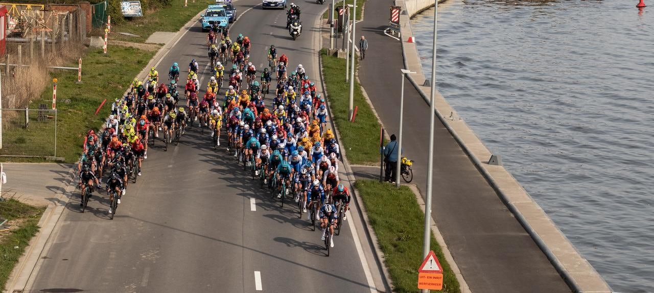 The peloton rattles along the Schelde River in 2023